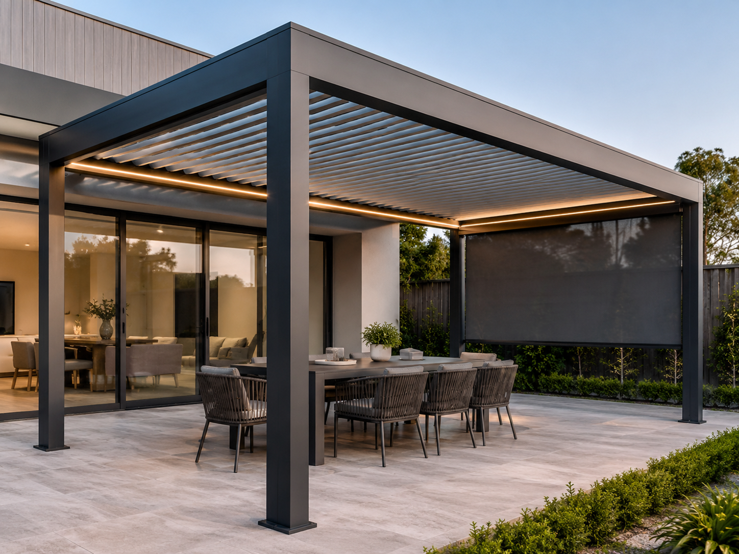 Modern Australian patio cover with aluminium louvered pergola, LED lighting and wind blind over outdoor dining area