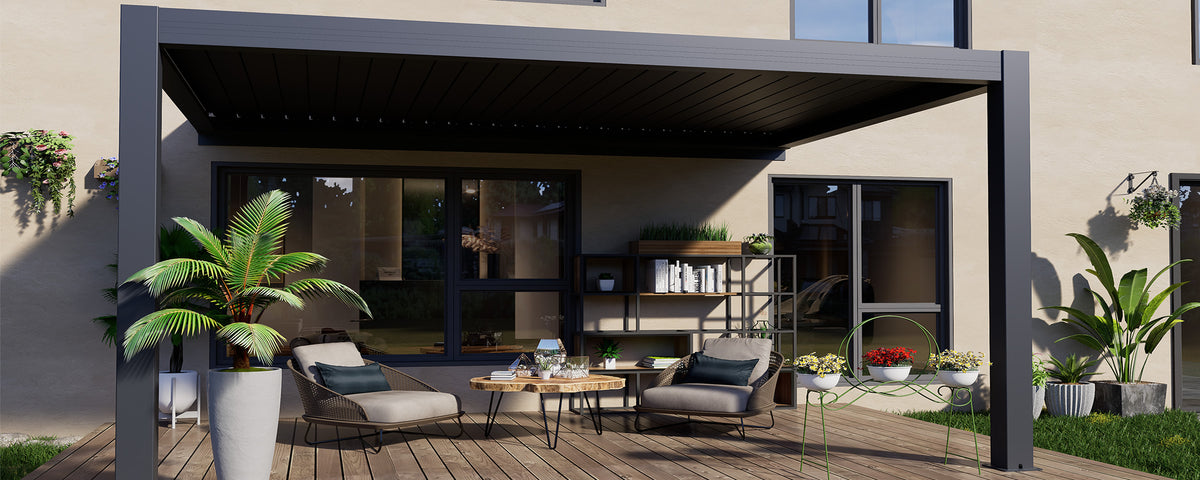 Dark aluminium pergola framing an open backyard lounge beside a house